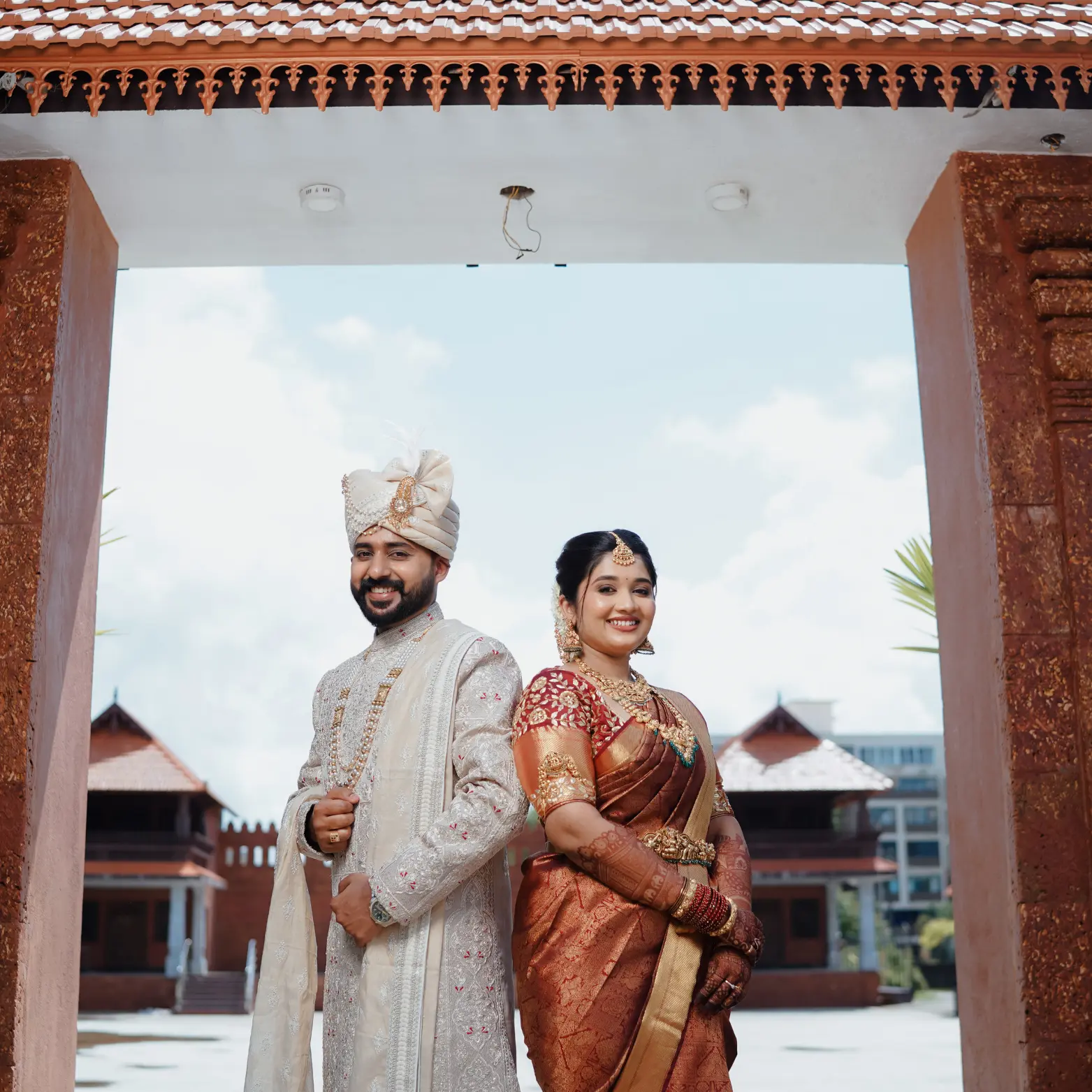 Wedding couple in a Rococo-inspired garden setting with soft pink pastel tones and ornate floral decorations